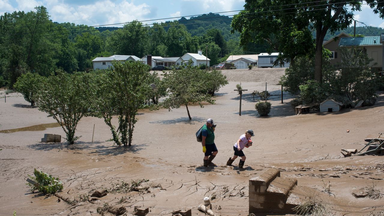 People trudge through the mud left over from the flooding of the Elk River in West Virginia in 2016. The flood claimed the lives of at least 23 people in the state.