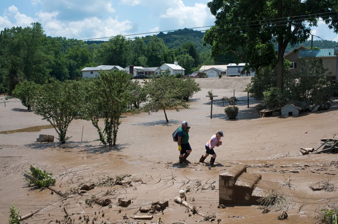 People trudge through the mud left over from the flooding of the Elk River in West Virginia in 2016. The flood claimed the lives of at least 23 people in the state.