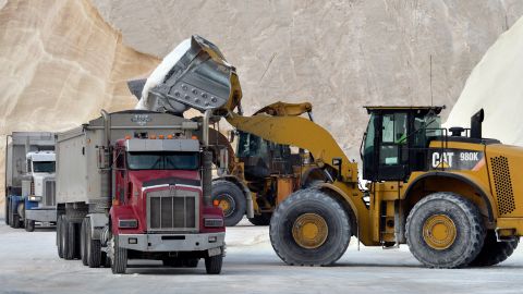 A bulldozer loads trucks with salt at Eastern Salt in Chelsea, Mass., on January 28, 2022.