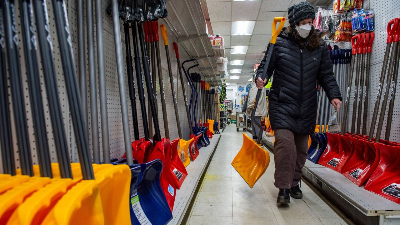 A woman carries a new shovel at Woodside Ace Hardware in Winthrop, Mass., on January 28, 2022.