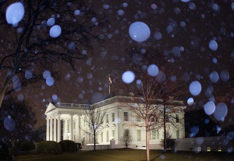 Snow falls around the White House in Washington, DC, on Friday.
