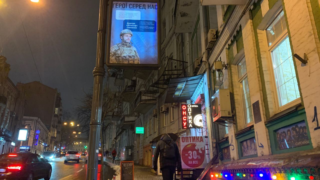 Street scene in Ukraine, with a poster that say "heroes are among us."