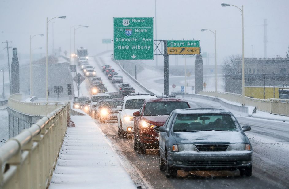 Slow traffic travels in the snow on Friday, in Louisville, Kentucky.