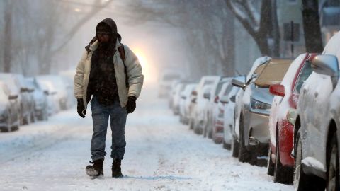 A man walks on a snow-covered street in Boston on Saturday morning.