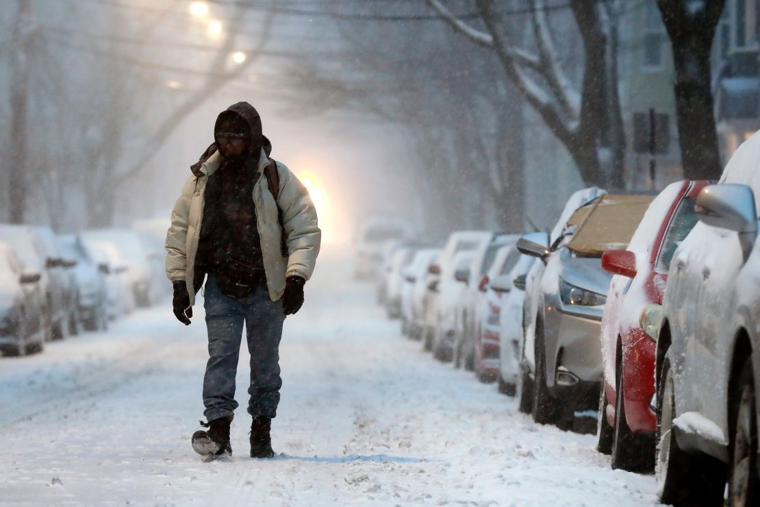 A man walks on a snow-covered street in Boston on Saturday morning.