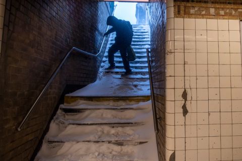 A man carefully walks down snow-covered subway stairs in Brooklyn, New York, on Saturday.