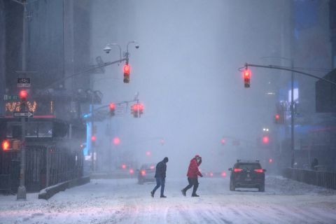 Pedestrians and motorists make their way through heavy snow in Times Square in New York on Saturday.