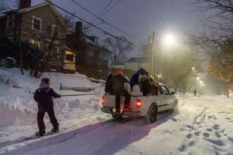 A person snowboards while pulled from a pickup truck in Providence, Rhode Island, on Saturday.