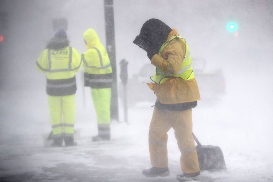 A worker shields himself from blowing snow in Boston, Massachusetts, on Saturday, January 29. 