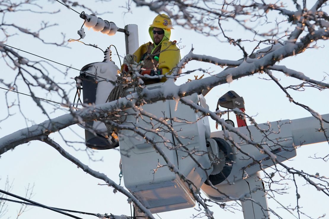 A lineman stands in an elevated platform Sunday while repairing damaged power lines in Chatham, Massachusetts.