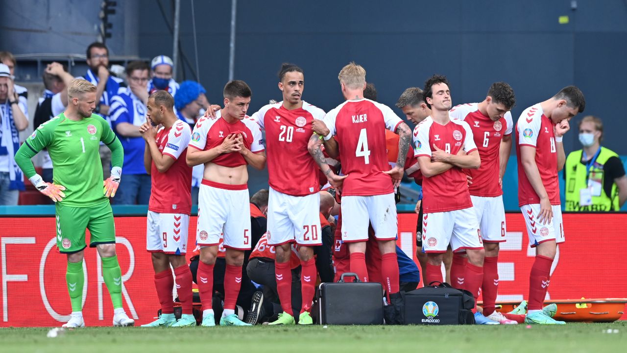 Denmark players look dejected as team mate Christian Eriksen (hidden) receives medical treatment during their Euro 2020 match against Finland. 