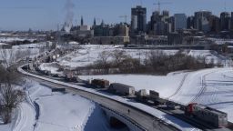 Vehicles of the protest convoy are seen parked on the Sir John A. Macdonald parkway leading in to downtown Ottawa on Jan. 30, 2022. Residents of the national capital are again being told to avoid traveling downtown as a convoy of trucks and cars snarl traffic protesting government-imposed vaccine mandates and COVID-19 restrictions. 