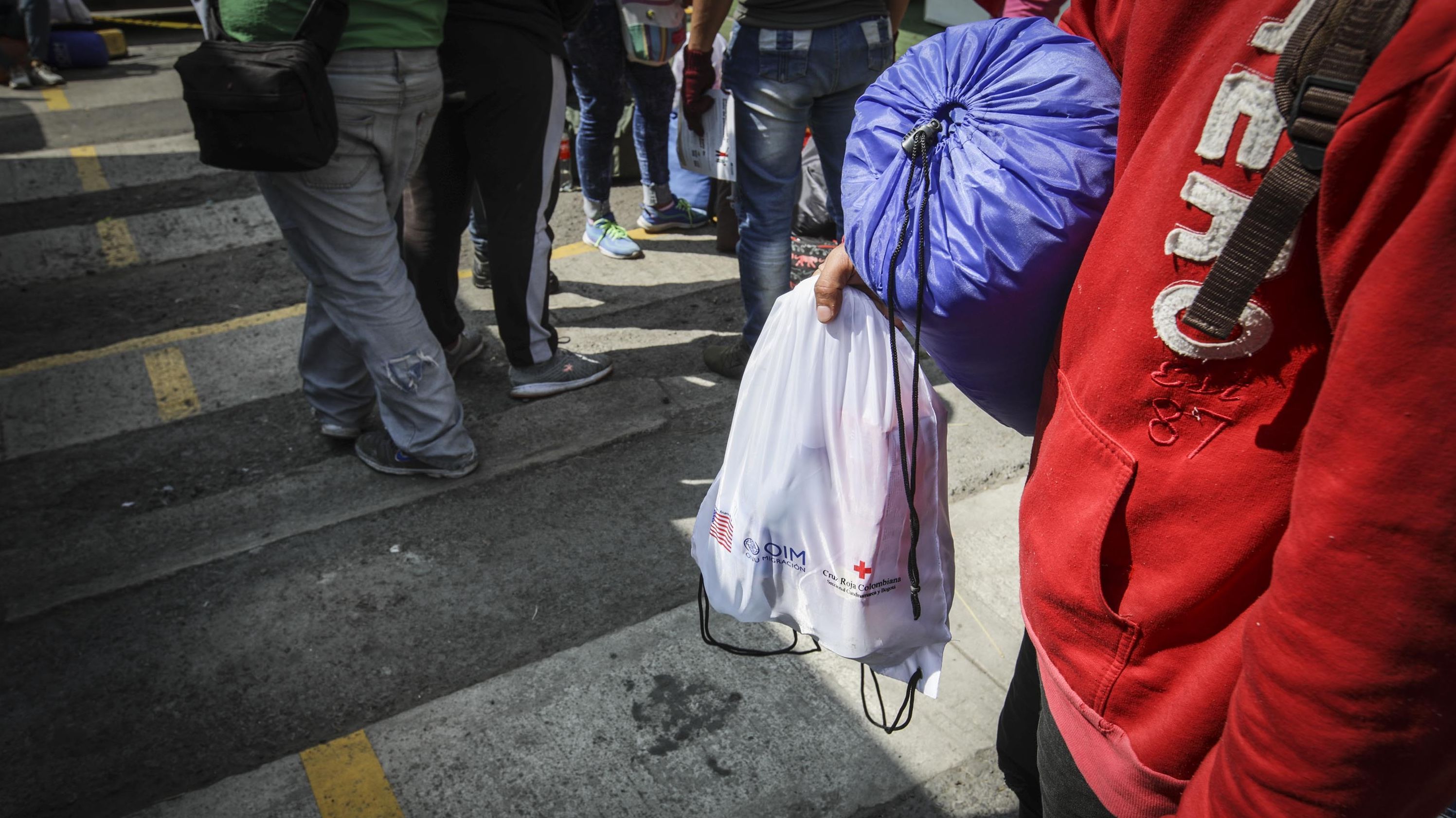 A group of Venezuelan migrants gather for food, medical aid at the International Red Cross, UN Refugee Agency, before continuing the march by foot to find countries like Ecuador, Peru, and Chile at the immigrant aid center on the roads in Sibate, Colombia on December 21, 2021.