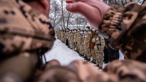 Reservists joining Ukraine's Territorial Defense Forces stand for the national anthem on their first day of training Saturday in Kharkiv. These men are volunteers who would help soldiers defend the country if needed.