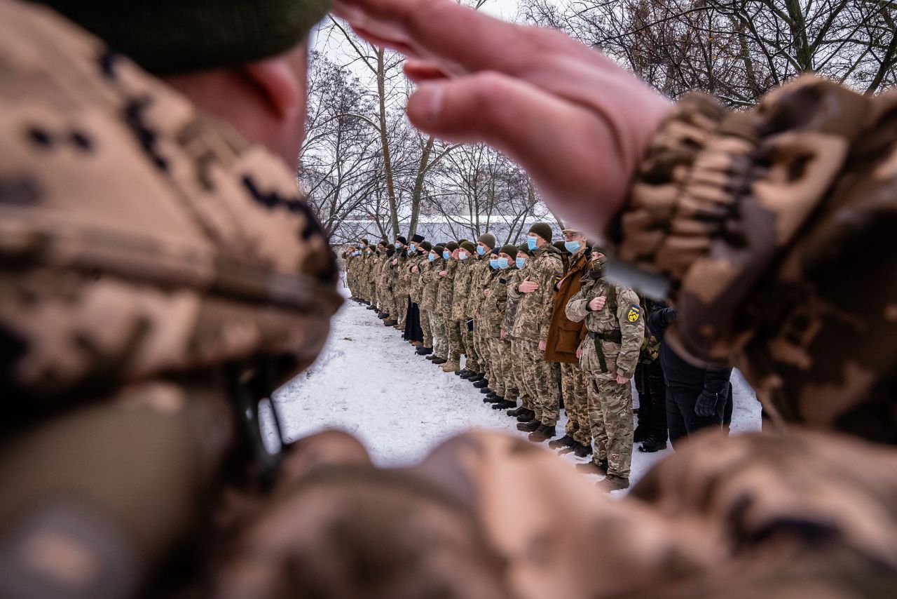 Reservists joining Ukraine's Territorial Defense Forces stand for the national anthem on their first day of training Saturday in Kharkiv. These men are volunteers who would help soldiers defend the country if needed.