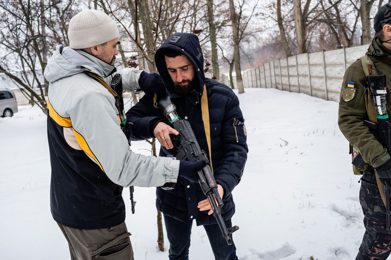 A man is taught how to use a rifle in Kharkiv.