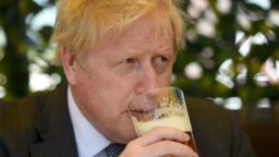 Britain's Prime Minister and leader of the Conservative Party, Boris Johnson, sips a pint of beer at an outside table during a visit to The Mount Tavern pub and restaurant in Wolverhampton, central England, on April 19, 2021, while campaigning for the upcoming local elections. - Local elections in England and Wales will go ahead on May 6 despite the coronavirus pandemic. (Photo by Jacob King / POOL / AFP) (Photo by JACOB KING/POOL/AFP via Getty Images)