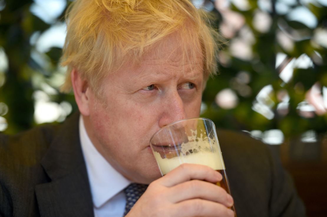Boris Johnson sips a pint of beer at a pub in Wolverhampton, central England, on April 19, 2021, while campaigning for local elections.
