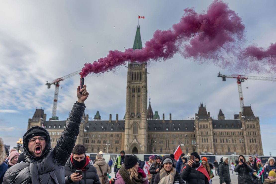 A man yells while holding a smoke firework during a protest against a Covid-19 vaccine mandate on Parliament Hill in Ottawa on Saturday.