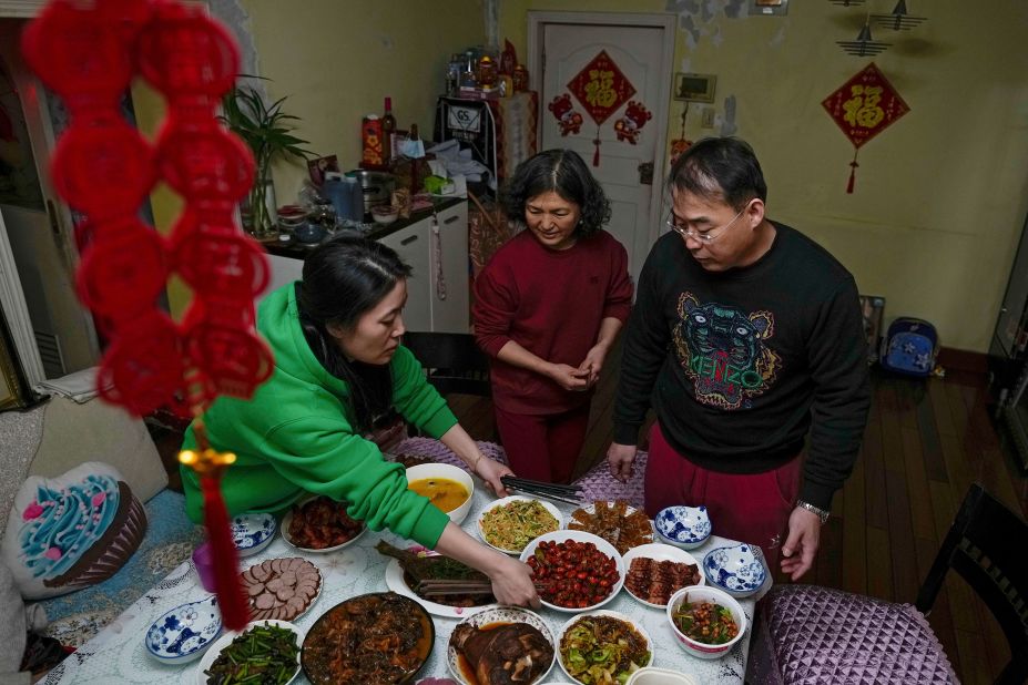 A woman, left, and her husband, right, prepare reunion dishes with a friend at a house in Beijing on January 31. Because of Covid-19 restrictions, they decided not to go back to their hometown for the Lunar New Year.