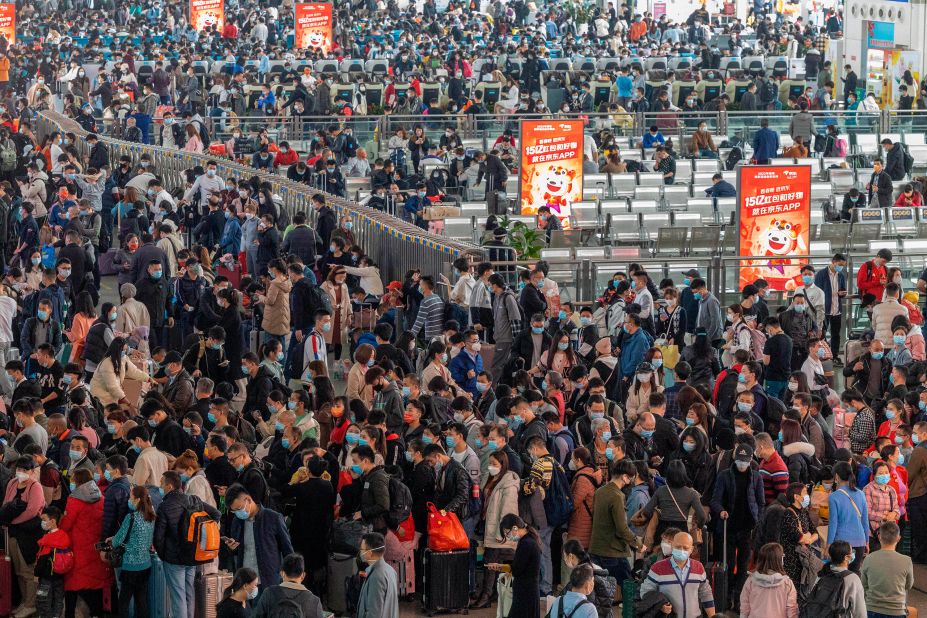 Travelers line up for trains at a station in Guangzhou, China, on Friday, January 28. Many people traditionally travel home to visit family members during the Lunar New Year.