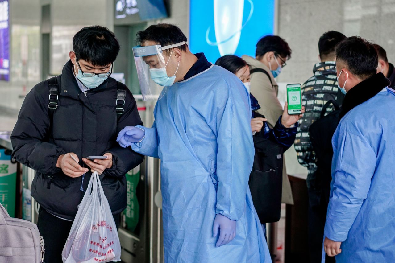 Staff members check passengers' health status at a train station entrance in Huzhou, China, on January 17.