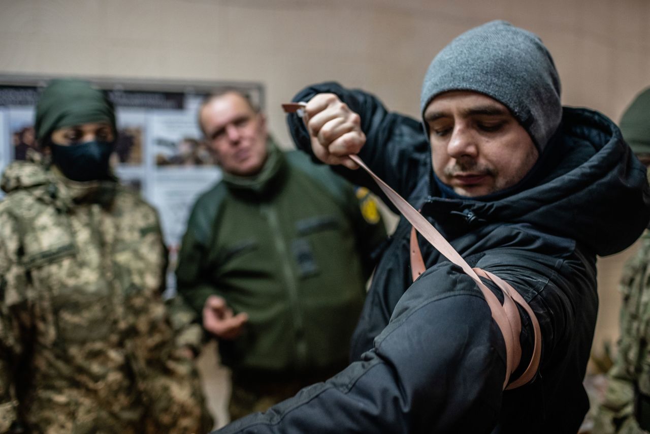 An army medic in Kharkiv instructs reservists on how to use a tourniquet.