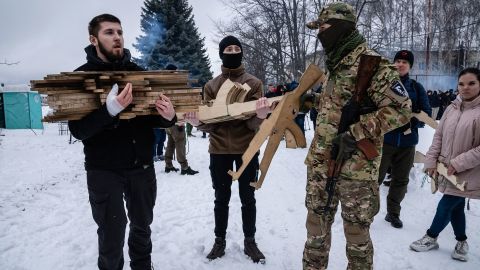 Civilians in Kyiv prepare to distribute wooden mock rifles in the shape of an AK-47.