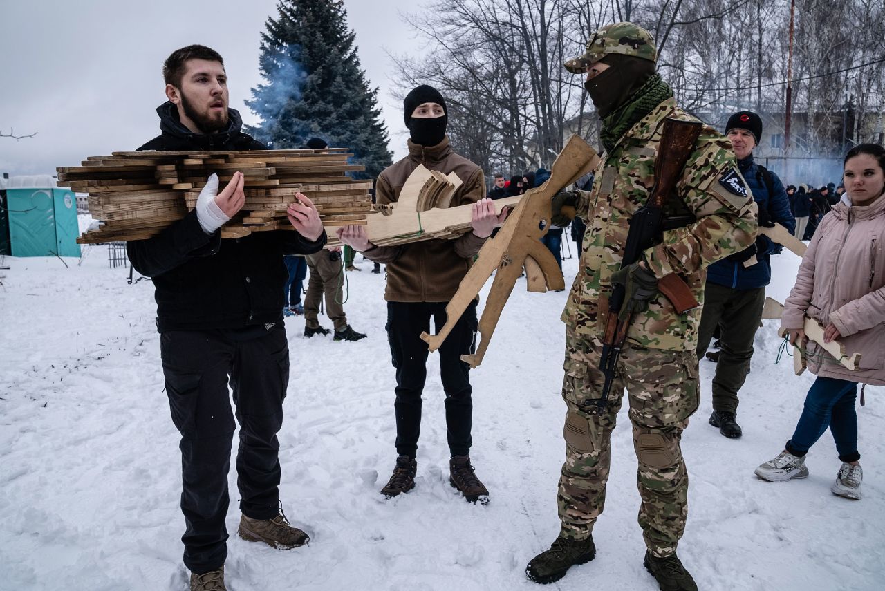 Civilians in Kyiv prepare to distribute wooden mock rifles in the shape of an AK-47.