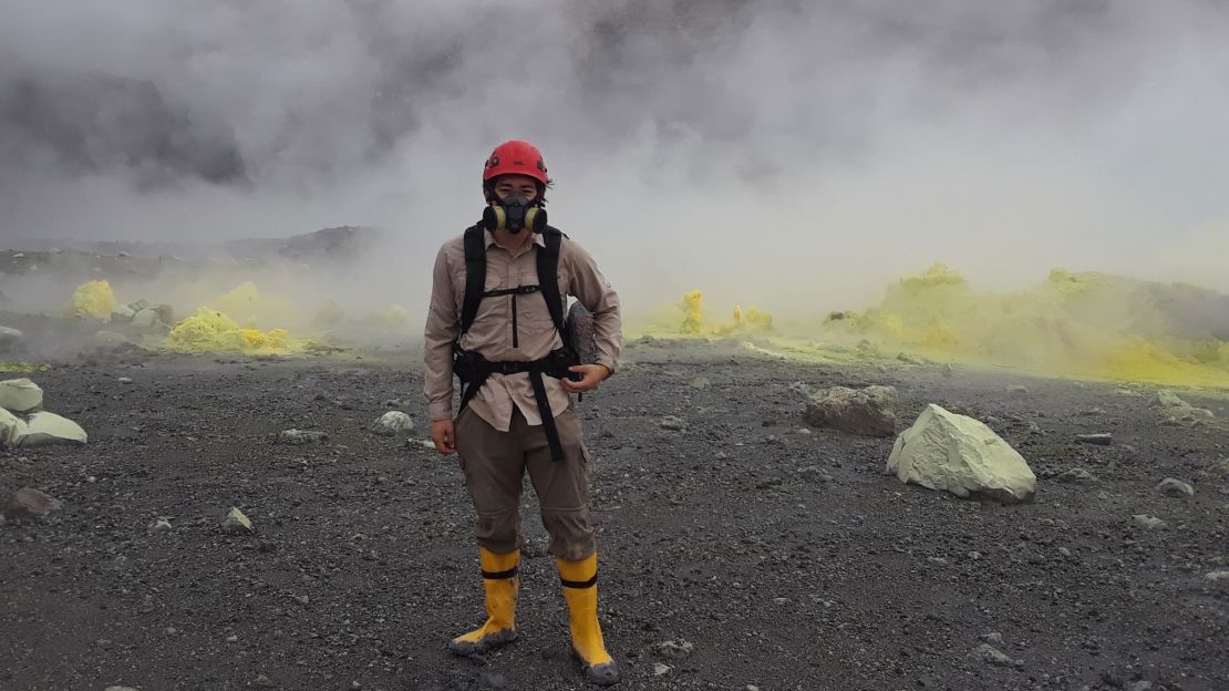 Justin Wang stands adjacent to fumaroles in the crater during field research in 2019.