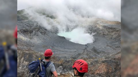 Researchers look down at Laguna Caliente after climbing out of the crater.