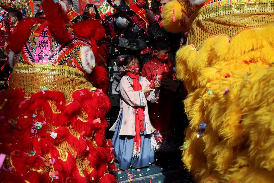 A girl in a traditional costume stands amid lion dancers during a Lunar New Year celebration in New York City on February 1.