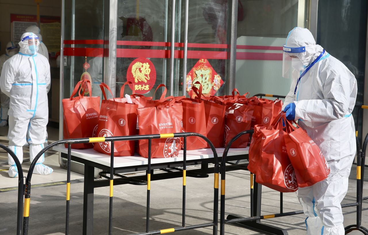 Staff members in protective suits prepare dumplings and other materials for 75 people in Beijing who were under Covid-19 quarantine on January 25.