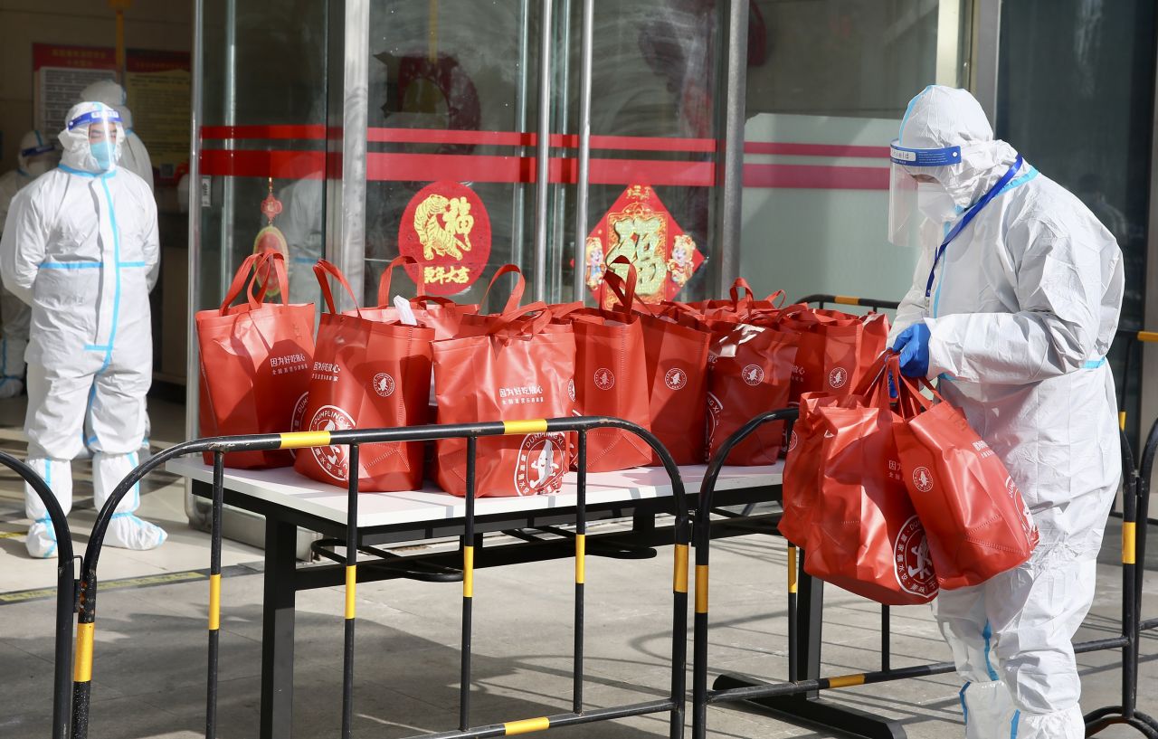 Staff members in protective suits prepare dumplings and other materials for 75 people in Beijing who were under Covid-19 quarantine on January 25.