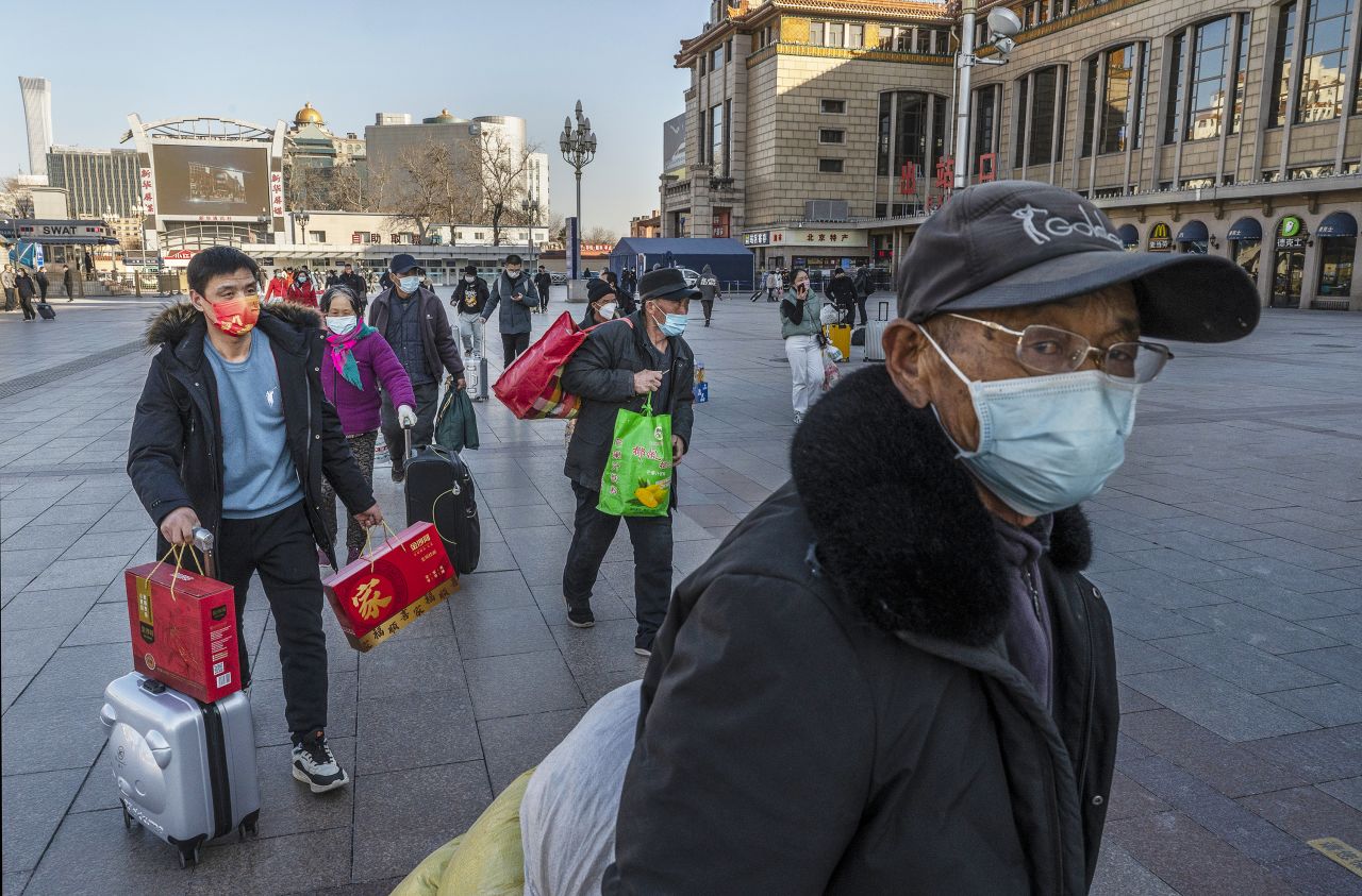 Travelers arrive for a train in Beijing on January 27.