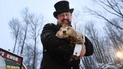 Groundhog Club handler A.J. Dereume holds Punxsutawney Phil, the weather prognosticating groundhog, during the 135th celebration of Groundhog Day on Gobbler's Knob in Punxsutawney, Pa., Tuesday, Feb. 2, 2021. Phil's handlers said that the groundhog has forecast six more weeks of winter weather during this year's event that was held without anyone in attendance due to potential COVID-19 risks. (AP Photo/Barry Reeger)