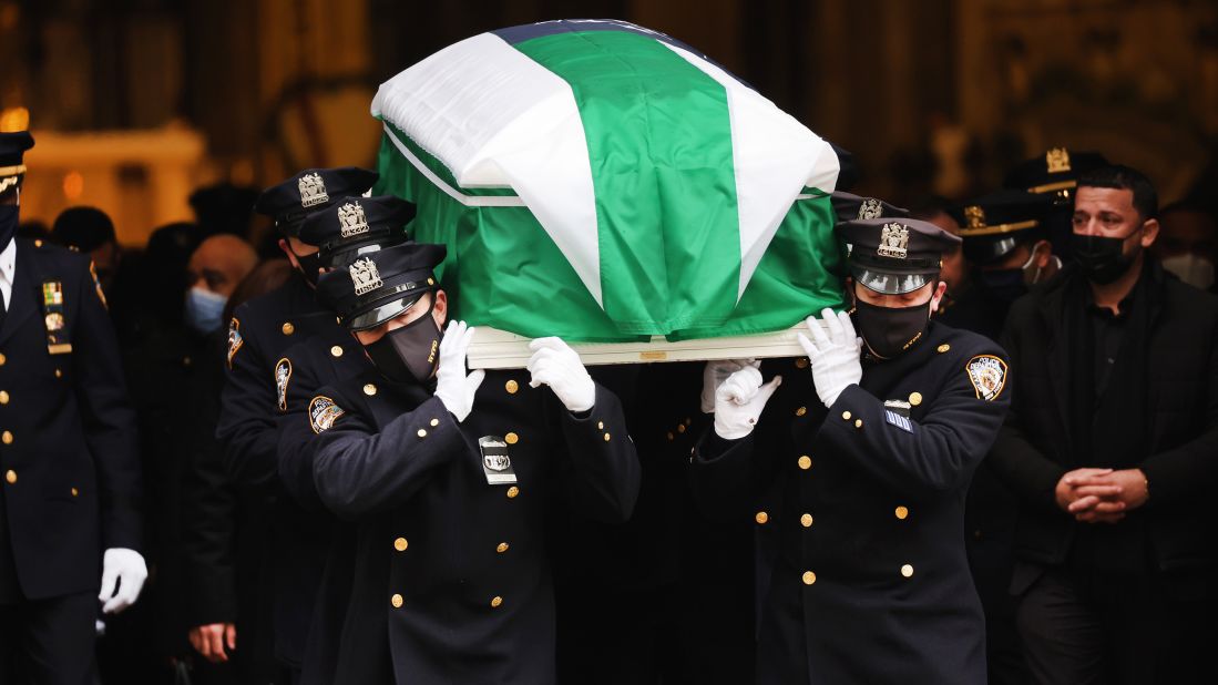 The casket of New York City police officer Wilbert Mora is carried out of St. Patrick's Cathedral on Wednesday, February 2. The flag over his casket is t he flag of the New York Police Department.