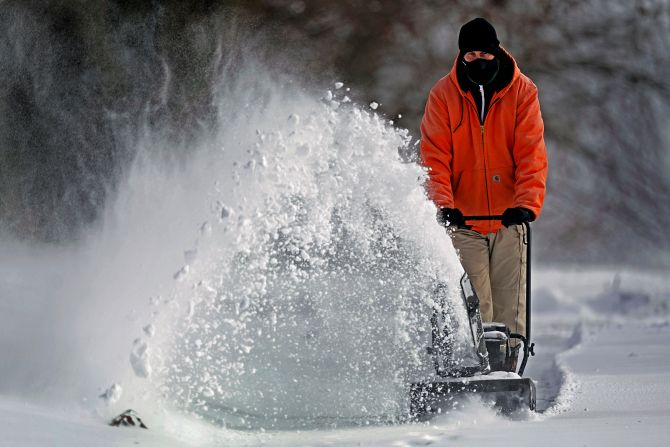 A man clears snow at his home in Overland Park, Kansas.