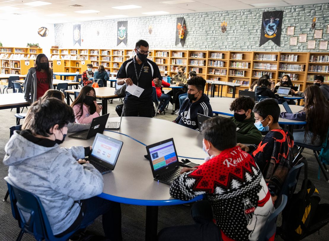 A substitute teacher at a Las Vegas middle school works with three classes of students at the school library in December 2021.