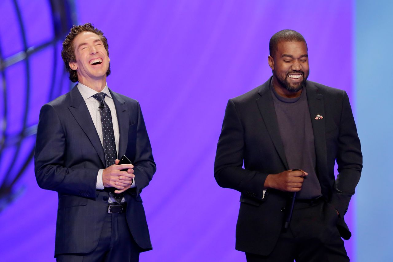 West makes a joke next to pastor Joel Osteen while leading a prayer at Osteen's Lakewood Church in Houston in 2019. West also put on one of his <a href="https://www.cnn.com/2019/11/16/us/kanye-west-lakewood-church-ticket-scalping-trnd/index.html" target="_blank">"Sunday Service" performances</a> at the church.