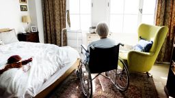 Senior woman sitting at home in a wheelchair