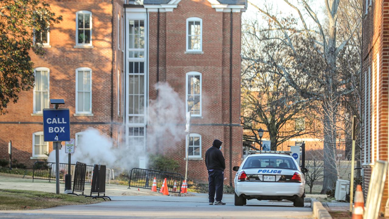 A man speaks with an officer outside Spelman College, which received a bomb threat Tuesday.
