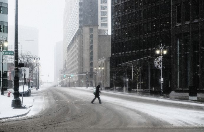 A pedestrian crosses a nearly empty road in Detroit.