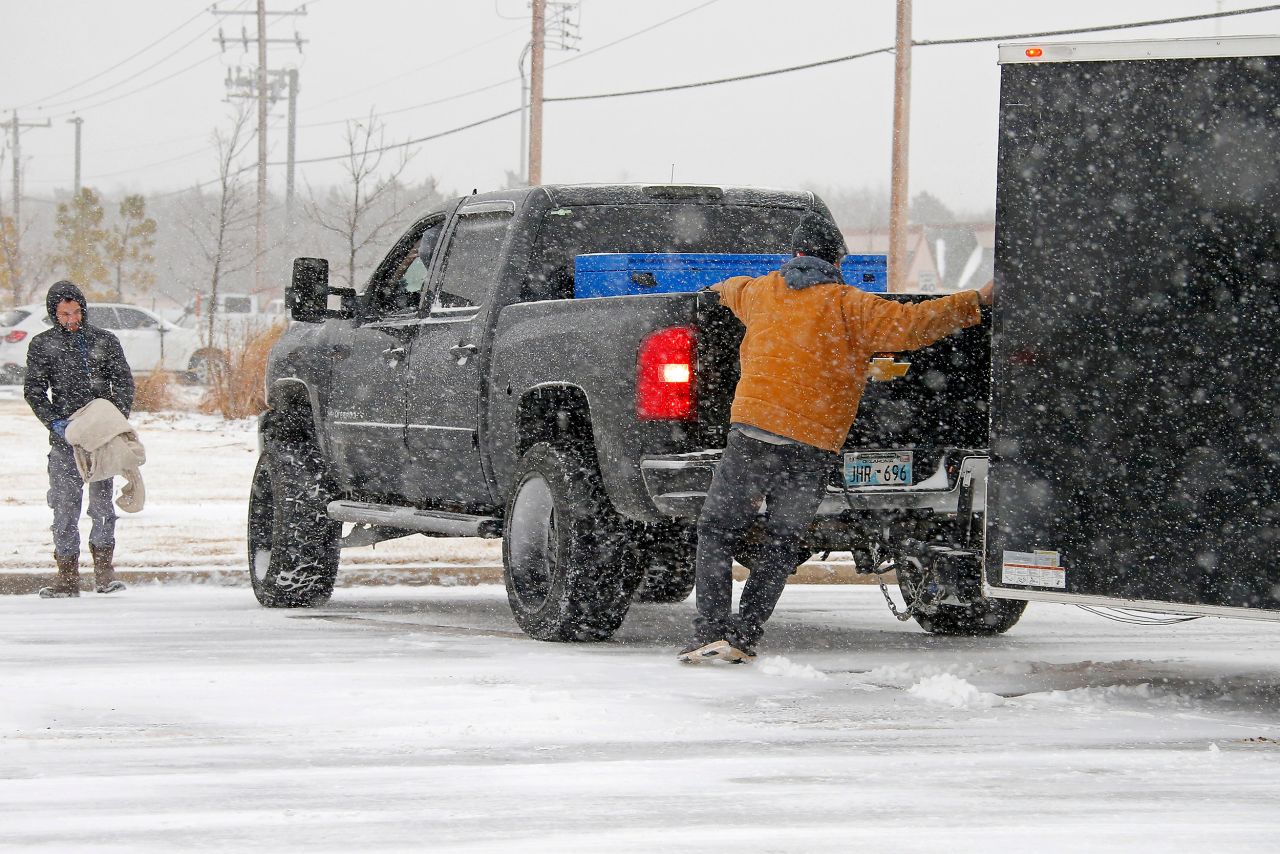 People try to help a motorist who was stuck in the snow in Oklahoma City.