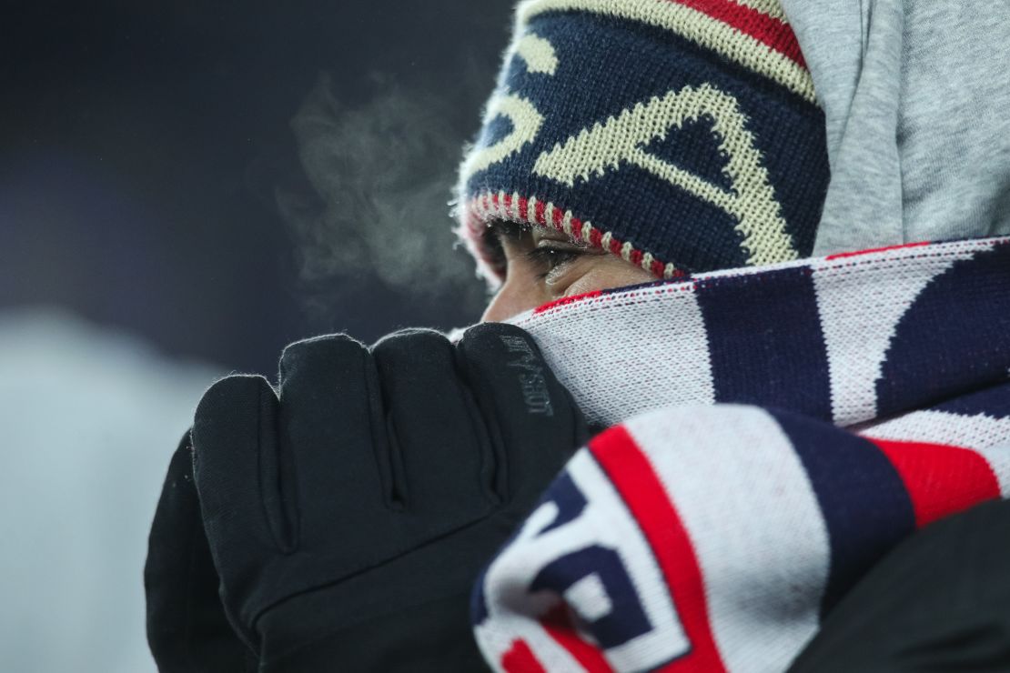 A fan tries to stay warm during the match.