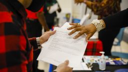 A job seeker receives information from a recruiter during a Miami-Dade County job fair in Miami, Florida, U.S., on Thursday, Dec. 16, 2021.