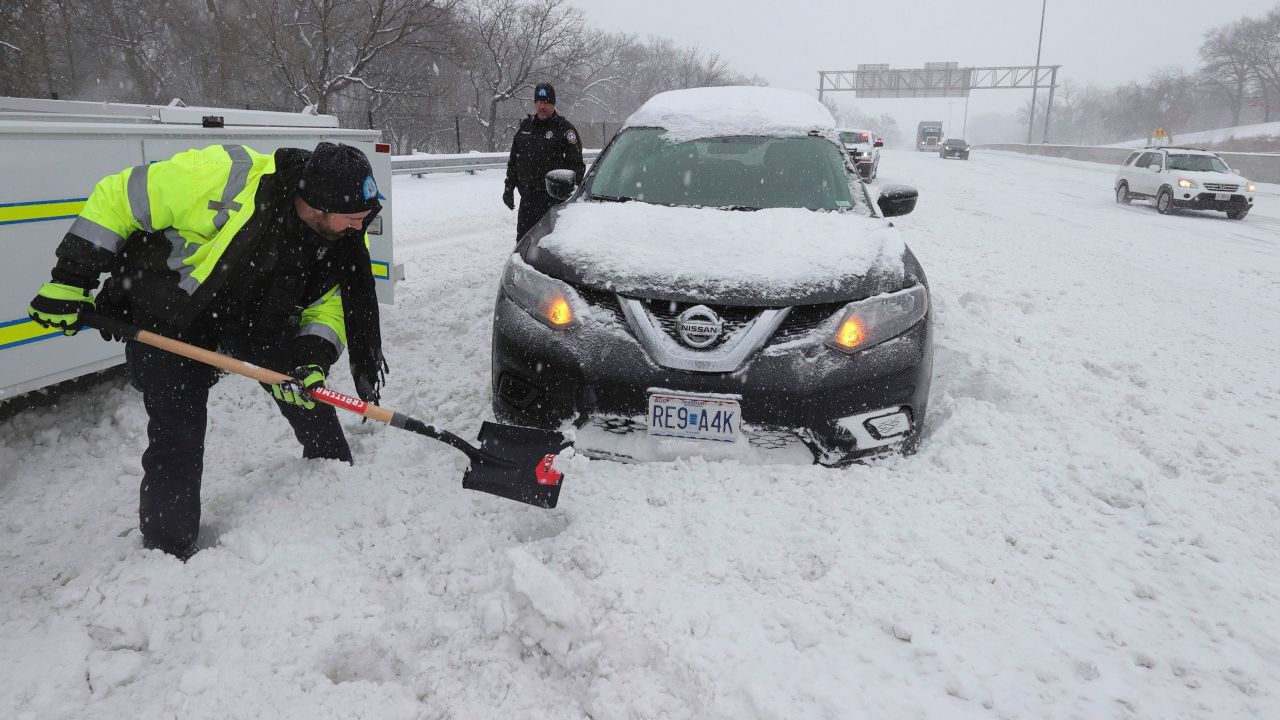 St. Louis police officers Eric Moran, left, and Scott Christian help a motorist who was stuck in snow at a highway exit on February 3.