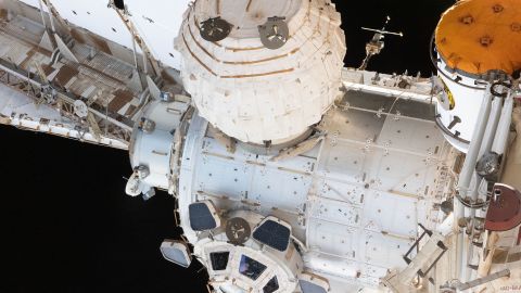 NASA astronaut and Expedition 66 Flight Engineer Kayla Barron peers out from a window inside the cupola, the International Space Station's "window to the world", on January 16. Prominent components in this photograph include the Tranquility module to which the cupola is attached, and the BEAM module.