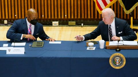 President Joe Biden hands a note to New York City Mayor Eric Adams during a discussion on gun violence strategies, at police headquarters, Thursday, February 3, 2022, in New York.