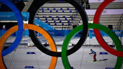 An athlete is pictured through the Olympic rings while training during a practice session on February 3, 2022, at the Zhangjiakou National Cross-Country Skiing Centre, ahead of the Beijing 2022 Winter Olympic Games. 